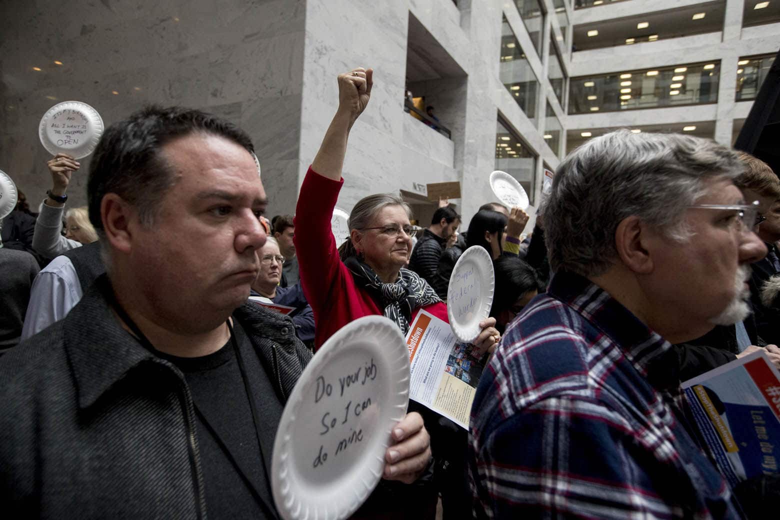 Furloughed government workers affected by the shutdown hold a silent protest against the ongoing partial government shutdown on Capitol Hill in Washington, Wednesday, Jan. 23, 2019. Protesters held up disposable plates instead of posters to avoid being arrested. (AP Photo/Andrew Harnik)