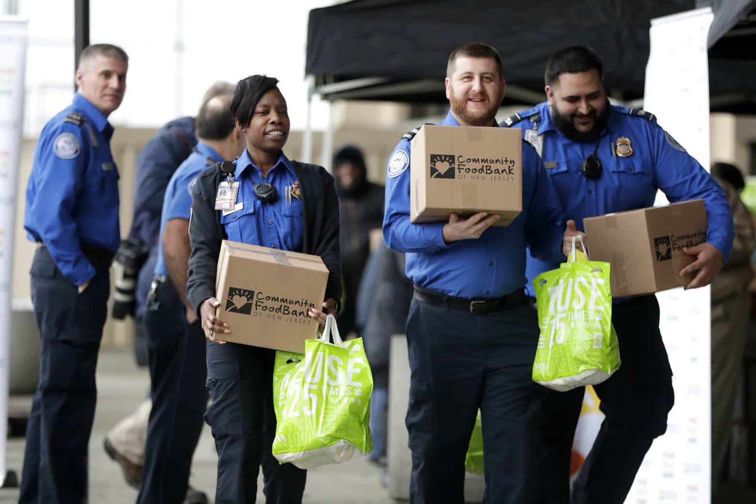 Transportation Security Administration employees carry boxes of non perishables and bags of produce received from the Community Food Bank at a drive at Newark Liberty International Airport to help government employees who are working without pay during the partial government shutdown, Wednesday, Jan. 23, 2019, in Newark, N.J. (AP Photo/Julio Cortez)