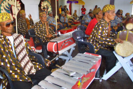Hendrik Wirdjo, left, and Johan Kromoredjo, right, lead the "The Young White Horses" Gamelan orchestra during the Indonesian "Wild Horse Dance" competition on Sunday, Aug. 4, 2002, in Paramaribo, Suriname. Dancing to the rhythm of a Gamelan orchestra, the dancers enter into a trance that causes them to act like tigers and monkeys and allows them to dance on fire. An Indonesian immigrant's association organizes the yearly competition to preserve the culture of the Surinamese of Indonesian descent, also knows as Javanese. On Monday, Aug. 5, the association will commemorate the 112th anniversary of the landing of the first boat of Indonesian immigrants in Suriname.(AP Photo/Edward Troon)
