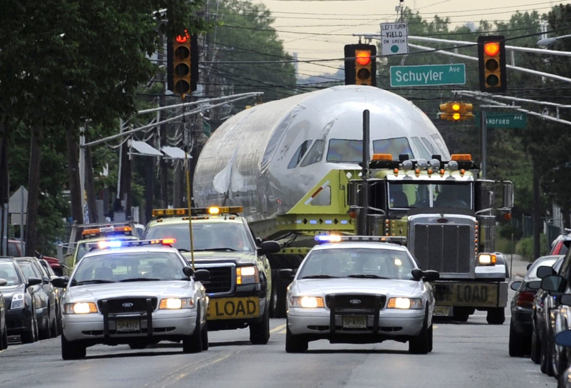 US Airways jet, flight 1549, is trucked onto local streets after leaving J. Supor and Sons warehouse in Harrison, N.J. Saturday, June 4, 2011. The plane that splash-landed in the Hudson River in 2009, making a national hero of pilot Chesley "Sully" Sullenberger, is being moved to an aviation museum in North Carolina, where it will be put on permanent display. (AP Photo/Bill Kostroun)