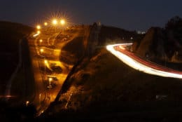 Floodlights from the U.S,, left, illuminate multiple border walls, center, as traffic flows along a street Monday, Jan. 7, 2019, in Tijuana, Mexico. With no breakthrough in sight, President Donald Trump will argue his case to the nation Tuesday night that a "crisis" at the U.S.-Mexico border requires the long and invulnerable wall he's demanding before ending the partial government shutdown. (AP Photo/Gregory Bull)