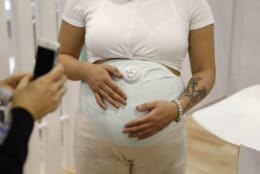A model wears the Owlet Band pregnancy monitor at the Owlet booth at CES International, Wednesday, Jan. 9, 2019, in Las Vegas. The device can track fetal heart rate, kicks and contractions. (AP Photo/John Locher)