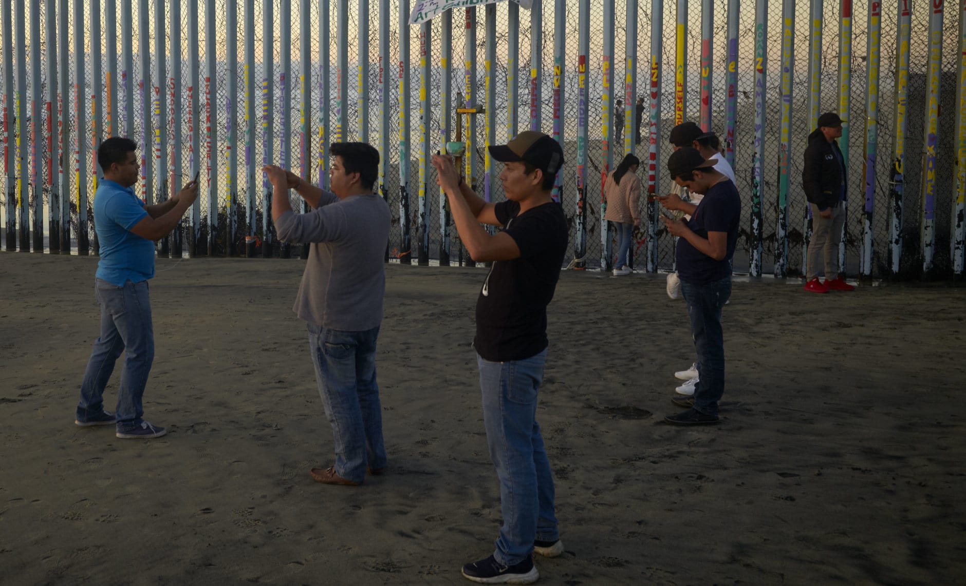 People record with their phones in front of the border wall Thursday, Jan. 10, 2019, along the beach in Tijuana, Mexico. Taking the shutdown fight to the Mexican border, U.S. President Donald Trump edged closer Thursday to declaring a national emergency in an extraordinary end run around Congress to fund his long-promised border wall. (AP Photo/Gregory Bull)