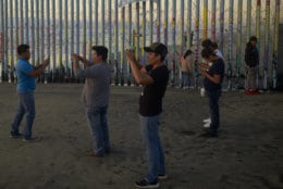 People record with their phones in front of the border wall Thursday, Jan. 10, 2019, along the beach in Tijuana, Mexico. Taking the shutdown fight to the Mexican border, U.S. President Donald Trump edged closer Thursday to declaring a national emergency in an extraordinary end run around Congress to fund his long-promised border wall. (AP Photo/Gregory Bull)