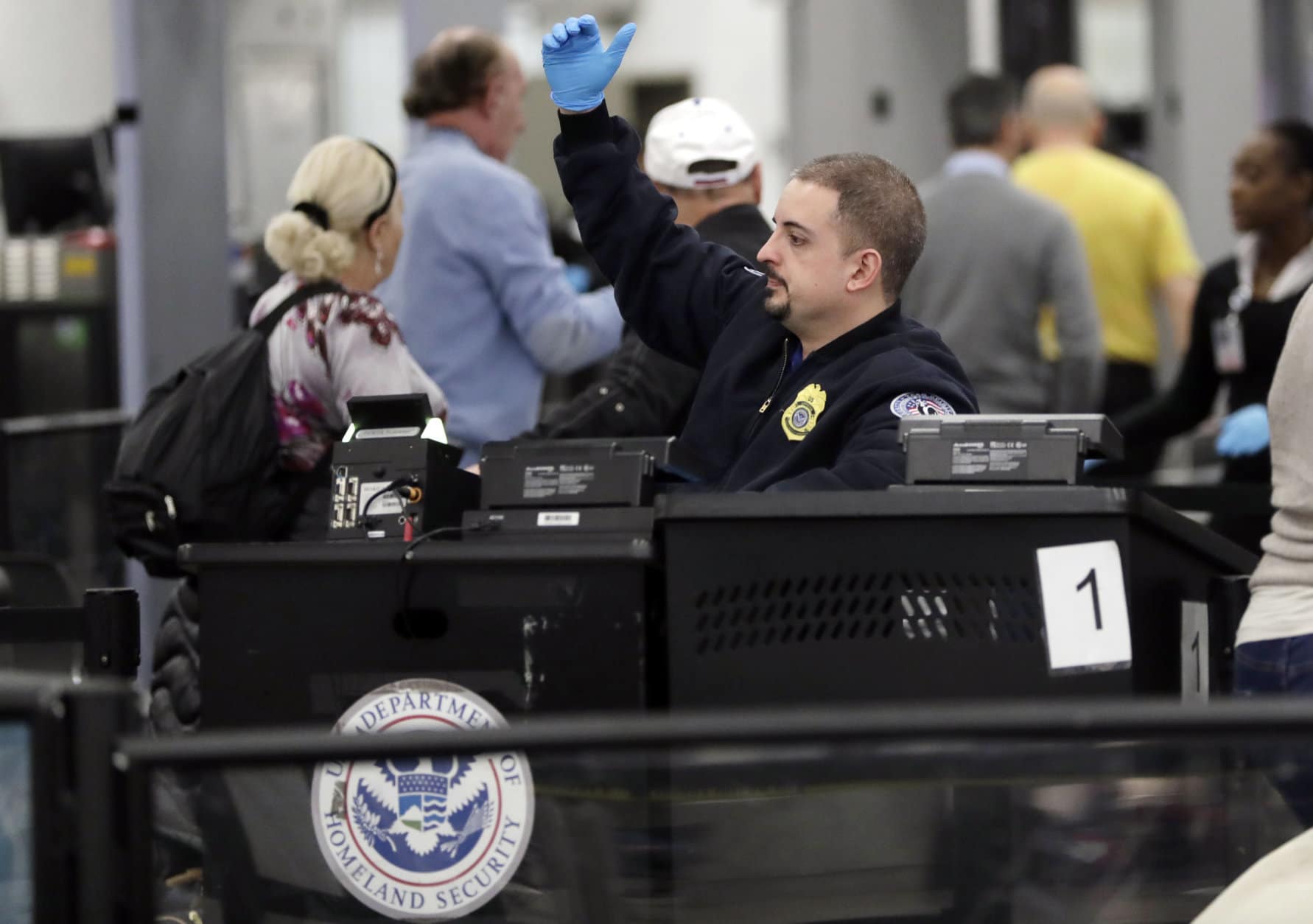 A Transportation Security Administration officer works at the entrance to Concourse G at Miami International Airport, Friday, Jan. 11, 2019, in Miami. The airport is closing Terminal G this weekend as the federal government shutdown stretches toward a fourth week because security screeners have been calling in sick at twice the airport's normal rate. (AP Photo/Lynne Sladky)