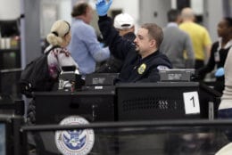A Transportation Security Administration officer works at the entrance to Concourse G at Miami International Airport, Friday, Jan. 11, 2019, in Miami. The airport is closing Terminal G this weekend as the federal government shutdown stretches toward a fourth week because security screeners have been calling in sick at twice the airport's normal rate. (AP Photo/Lynne Sladky)
