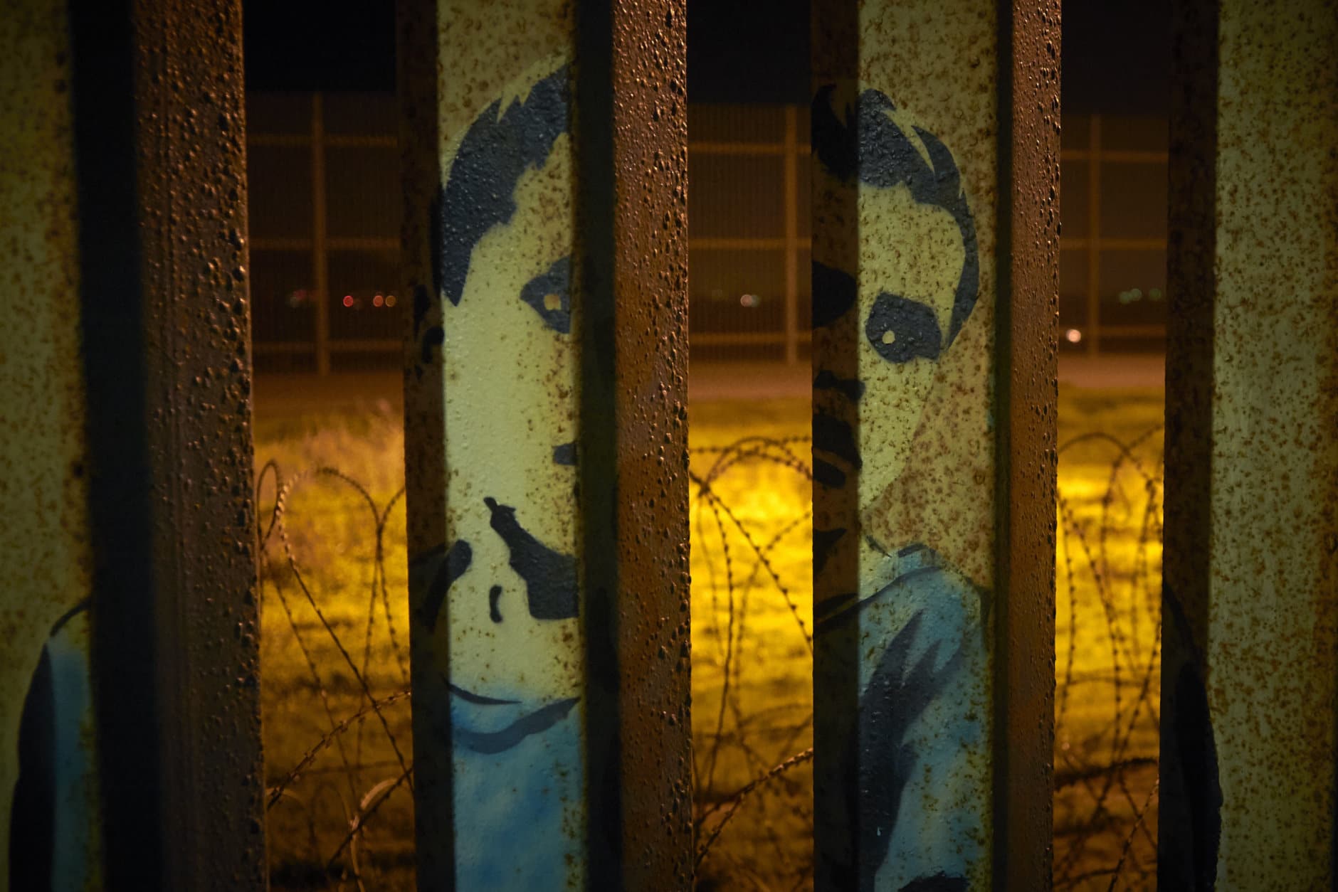 An image of a boy is painted on the bars of the border wall, in front of coils of razor wire Friday, Jan. 11, 2019, seen from Tijuana, Mexico. The partial government shutdown was on track Friday to become the longest closure in U.S. history as President Donald Trump and nervous Republicans looked for a way out of the mess. A solution couldn't come soon enough for federal workers who got pay statements Friday but no pay. (AP Photo/Gregory Bull)