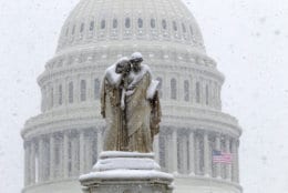 The U.S. Capitol is see behind the Peace Monument during a snowstorm, as a partial government shutdown stretches into its third week at Capitol Hill in Washington Sunday, Jan. 13, 2019. With the standoff over paying for his long-promised border wall dragging on, the president's Oval Office address and visit to the Texas border over the past week failed to break the logjam and left aides and allies fearful that the president has misjudged Democratic resolve and is running out of negotiating options. (AP Photo/Jose Luis Magana)