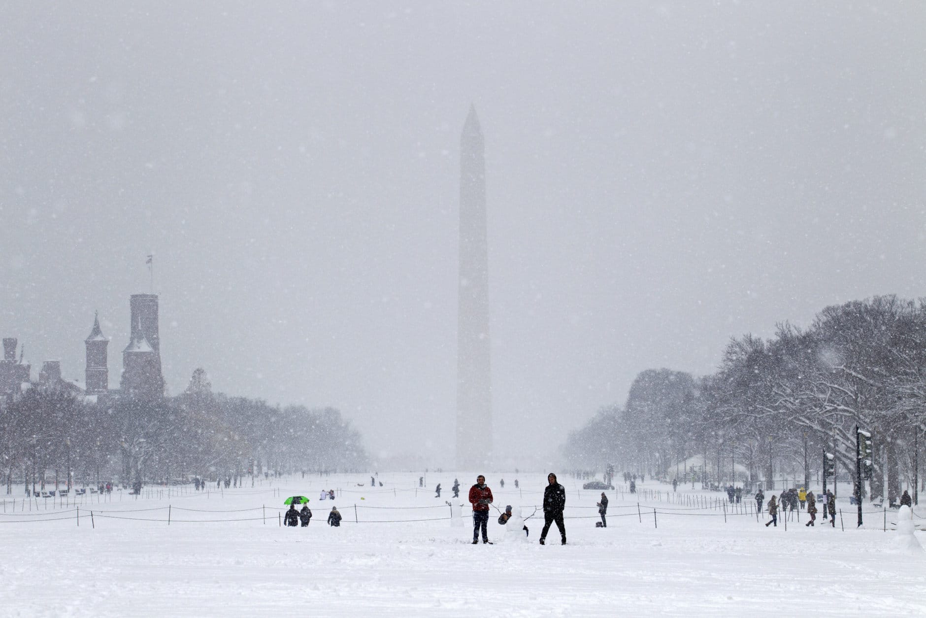 People play with snow at the National Mall during a snowstorm, as a partial government shutdown stretches into its third week at Capitol Hill in Washington Sunday, Jan. 13, 2019. With the standoff over paying for his long-promised border wall dragging on, the president's Oval Office address and visit to the Texas border over the past week failed to break the logjam and left aides and allies fearful that the president has misjudged Democratic resolve and is running out of negotiating options. (AP Photo/Jose Luis Magana)