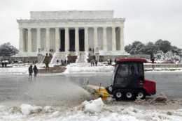 Park service workers clean the snow outside of Lincoln Memorial, during a snowstorm, as a partial government shutdown stretches into its third week at Capitol Hill in Washington Sunday, Jan. 13, 2019. With the standoff over paying for his long-promised border wall dragging on, the president's Oval Office address and visit to the Texas border over the past week failed to break the logjam and left aides and allies fearful that the president has misjudged Democratic resolve and is running out of negotiating options. (AP Photo/Jose Luis Magana)