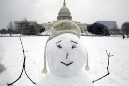 The U.S. Capitol is seen behind a snowman during a snowstorm, as a partial government shutdown stretches into its third week at Capitol Hill in Washington Sunday, Jan. 13, 2019. With the standoff over paying for his long-promised border wall dragging on, the president's Oval Office address and visit to the Texas border over the past week failed to break the logjam and left aides and allies fearful that the president has misjudged Democratic resolve and is running out of negotiating options. (AP Photo/Jose Luis Magana)