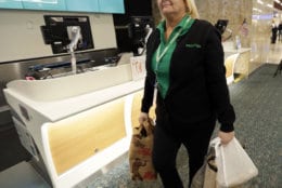 Chantele Montover, a counter agent with Frontier Airlines, takes food donations to a distribution point for to be given to TSA workers at Orlando International Airport Tuesday, Jan. 15, 2019, in Orlando, Fla. Florida airports are helping federal workers who aren't getting paid during the government shutdown by offering free food, holding a food drive and opening a food bank.  (AP Photo/John Raoux)