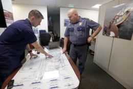 U.S. Coast Guard Lt. Cmdr. Blair Sweigert, left, who missed a paycheck a day earlier during the partial government shutdown, works with Washington State Patrol Capt. Dan Atchison in a shared office where they coordinate marine security at Sector Puget Sound base Wednesday, Jan. 16, 2019, in Seattle. The Coast Guard is part of the U.S. Department of Homeland Security, which is unfunded during the shutdown, now in its fourth week. (AP Photo/Elaine Thompson)