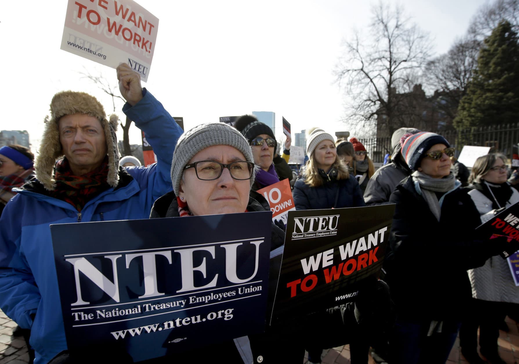 United States Department of Agriculture employee Lori Lodato, of Wilmington, Mass., display placards during a rally by federal employees and supporters, Thursday, Jan. 17, 2019, in front of the Statehouse in Boston, held to call for an end of the partial shutdown of the federal government. (AP Photo/Steven Senne)