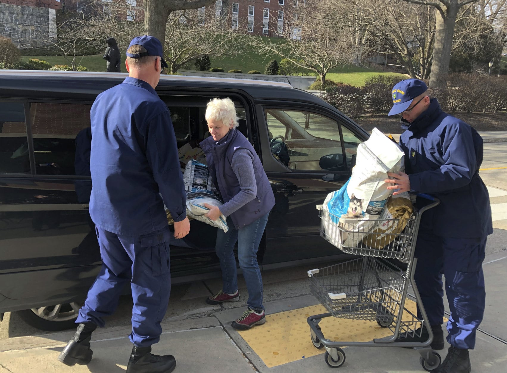 In this Thursday, Jan. 17, 2019 photo, Christine Lamb, president and founder of the nonprofit group Animal House Inc., in nearby Waterford, Conn., delivers bags of donated pet food to Coast Guardsmen helping at a pop-up food pantry created on the grounds of the U.S. Coast Guard Academy in New London, Conn. Hundreds of Coast Guard civilian and non-civilian employees working at the academy and at other Coast Guard installations have been impacted by the partial federal shutdown and have not received a paycheck in weeks. (AP Photo/Susan Haigh)