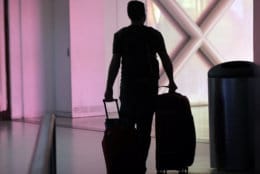 A traveler walks through Miami International Airport, Friday, Jan. 18, 2019, in Miami. The three-day holiday weekend is likely to bring bigger airport crowds. (AP Photo/Lynne Sladky)