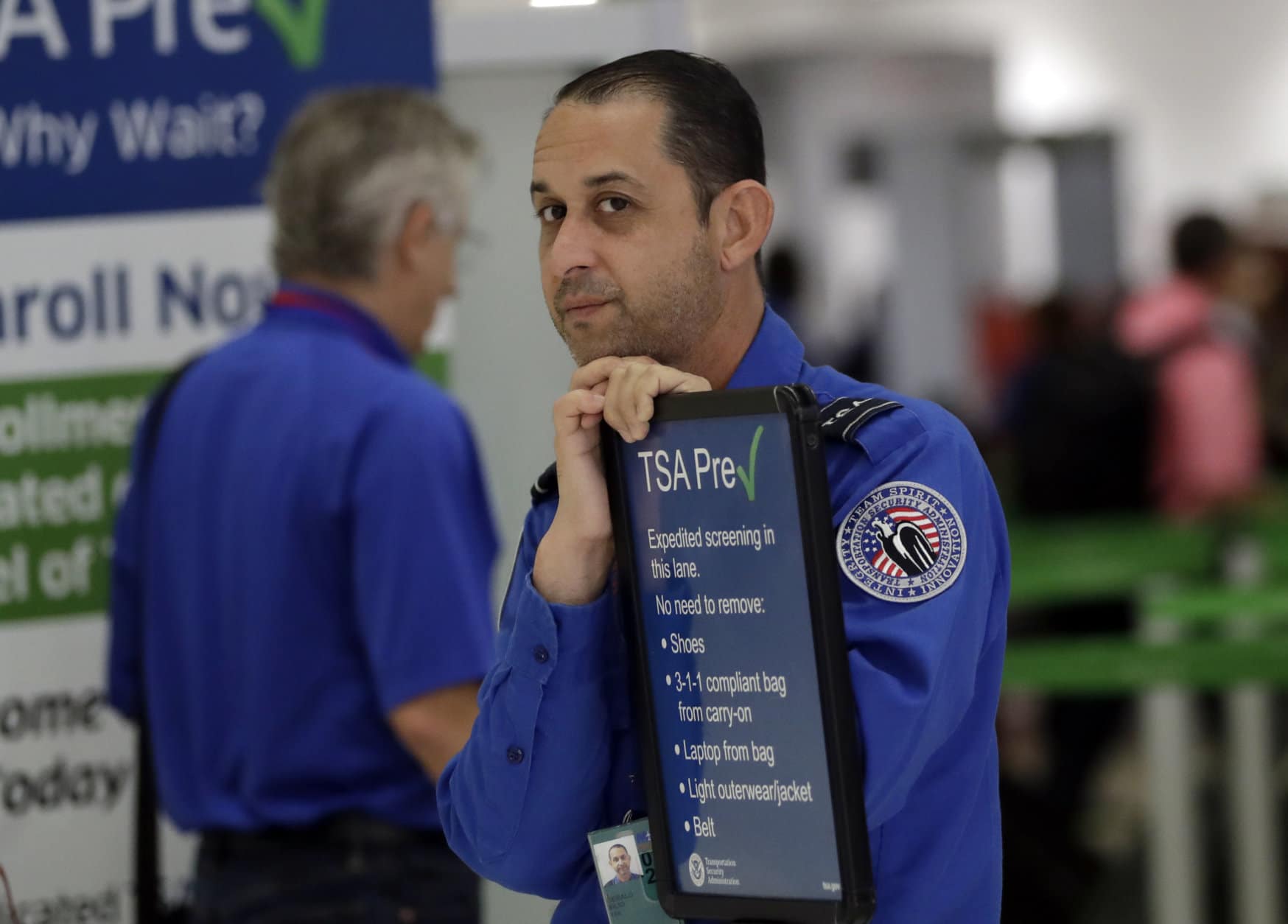 A Transportation Security Administration (TSA) employee works at a security checkpoint at Miami International Airport, Friday, Jan. 18, 2019, in Miami. The three-day holiday weekend is likely to bring bigger airport crowds. (AP Photo/Lynne Sladky)