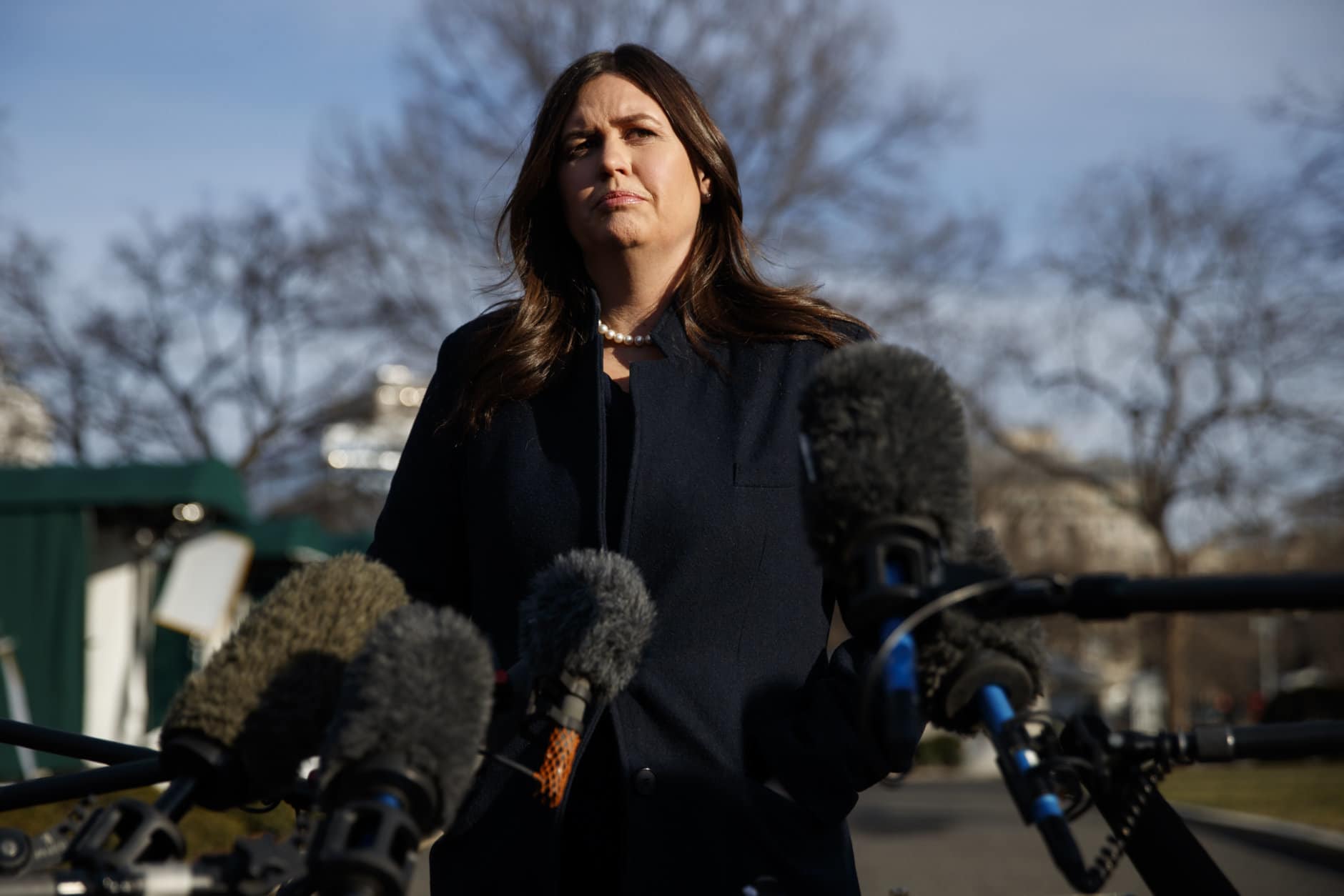 White House press secretary Sarah Huckabee Sanders listens to a question as she speaks with reporters outside the White House, Friday, Jan. 25, 2019, in Washington. (AP Photo/ Evan Vucci)