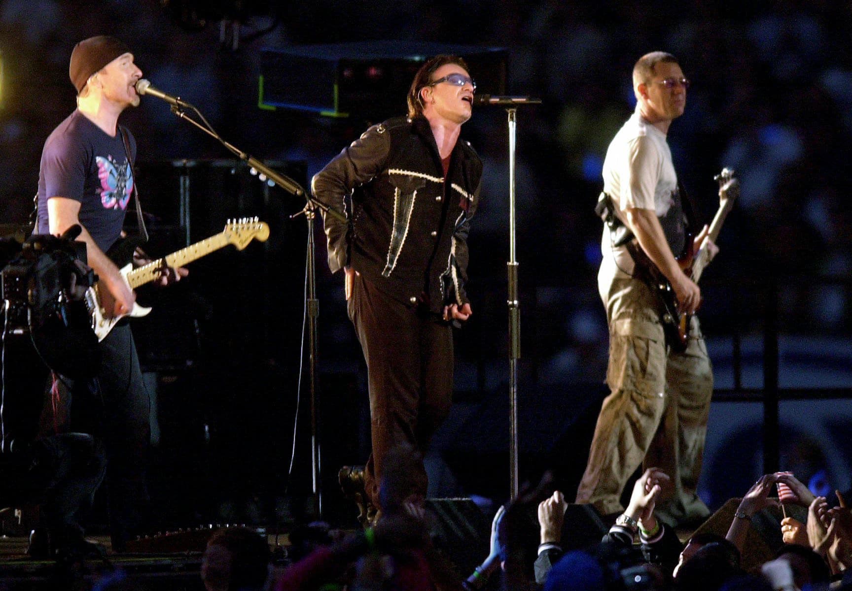 FILE - In this Feb. 3, 2002 file photo, The Edge, from left, Bono and Adam Clayton, of U2, perform during the halftime show of Super Bowl XXXVI at the Louisiana Superdome in New Orleans. At the first Super Bowl following the 2001 terrorist attacks, U2 performed "Where the Streets Have No Name" as a giant scrim behind them unfurled names of the Sept. 11 victims. (AP Photo/Tony Gutierrez, File)