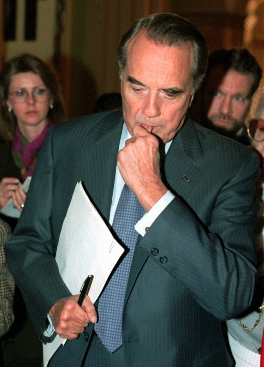 Senate Majority Leader Bob Dole of Kansas ponders a reporters question as he walks on Capitol Hill Thursday Dec. 21, 1995. The White House and Congressional Republicans labored Thursday to restart balanced budget talks and grappled with the impact of a six-day partial government shutdown. (AP Photo/Denis Paquin) 