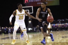 Buffalo's CJ Massinburg, right, drives to the basket against Milwaukee's Darius Roy during the first half of an NCAA college basketball game between the Buffalo Bulls and the Milwaukee Panthers, Friday, Nov. 30, 2018, in Belfast. (AP Photo/Peter Morrison)