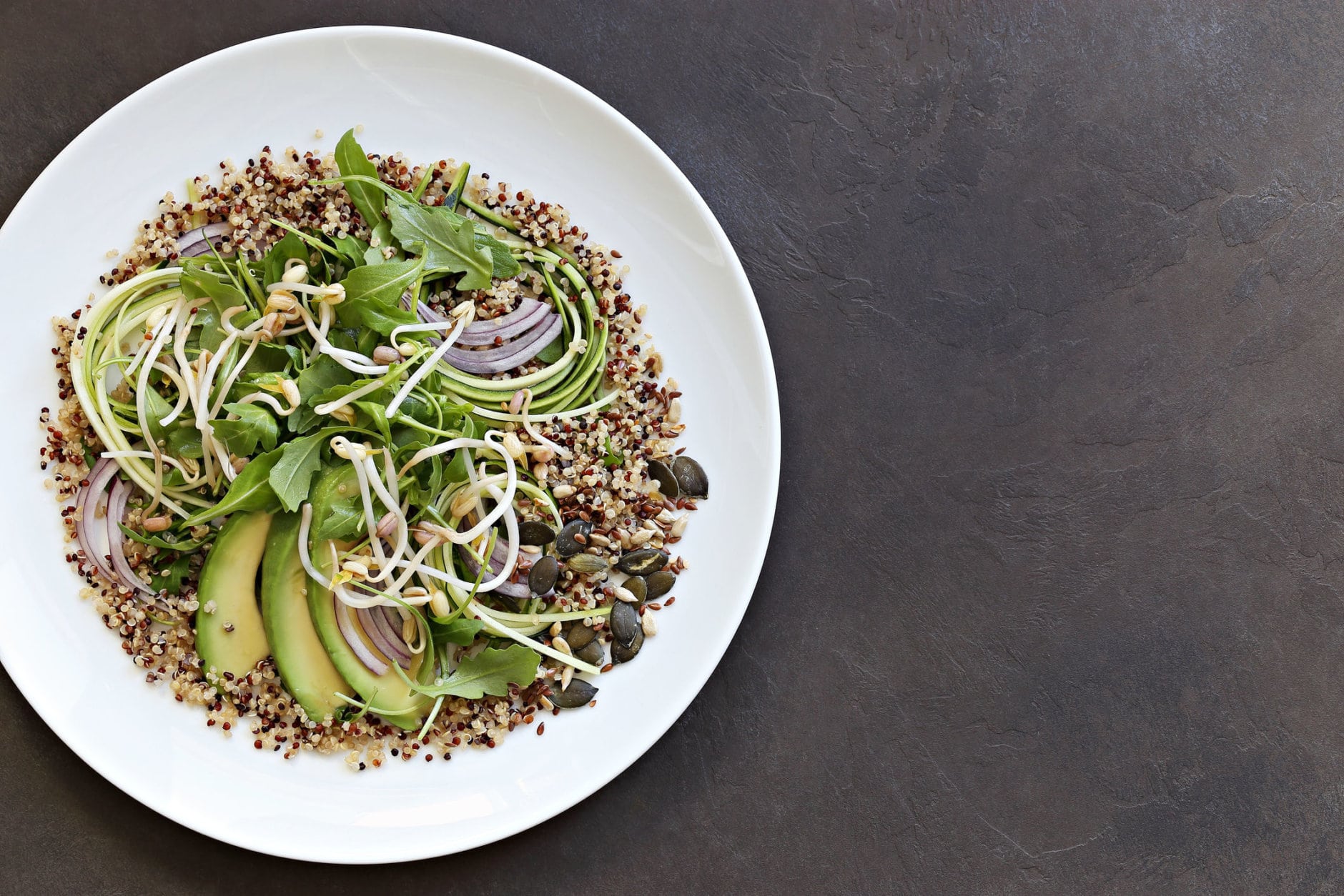 Quinoa detox salad with avocado, arugula, zucchini and seed mix. Plant based, clean eating, keto, super food.