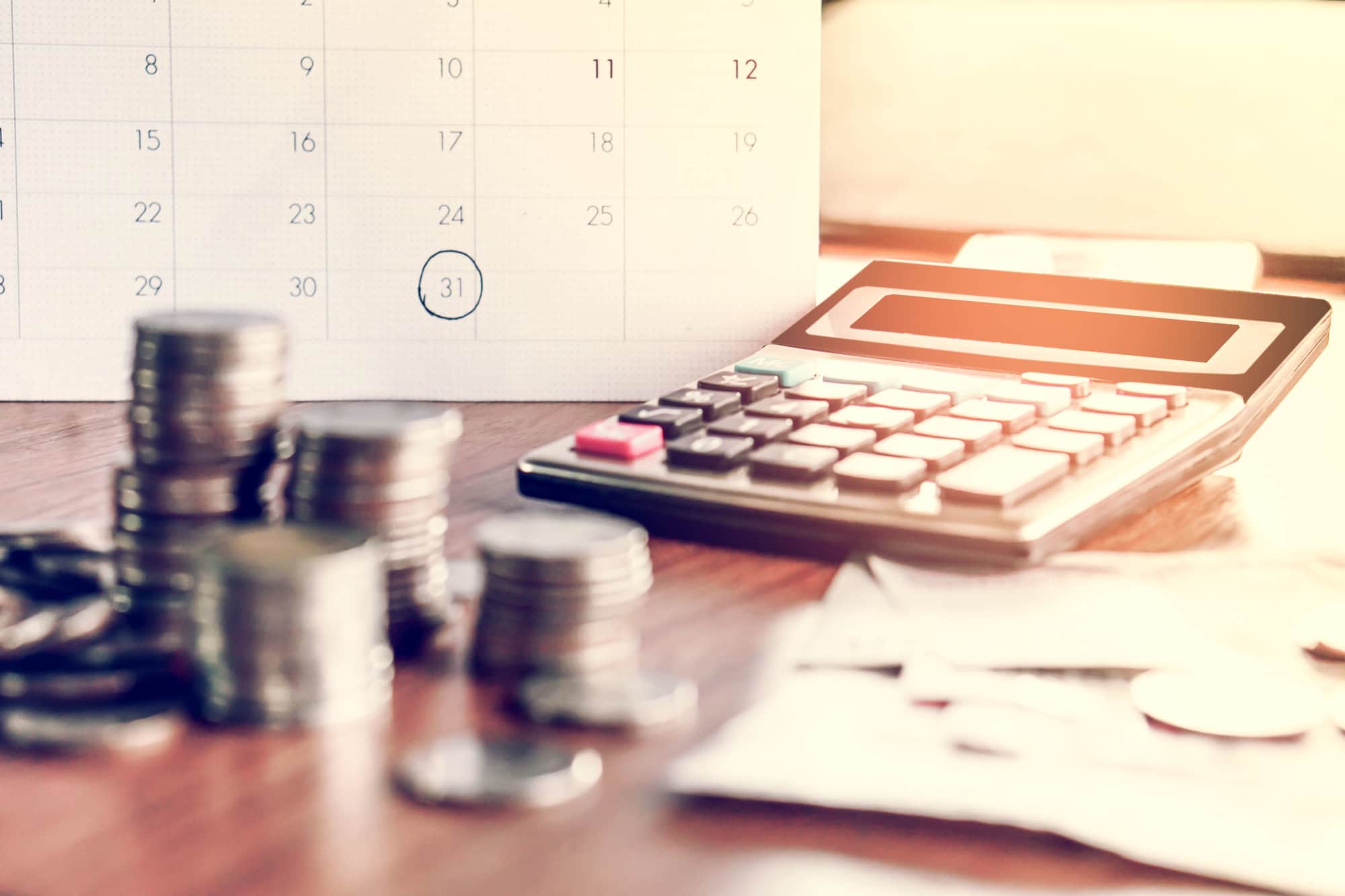 debt collection and tax season concept with deadline calendar remind note,coins,banks,calculator on table, background ,time to pay concept