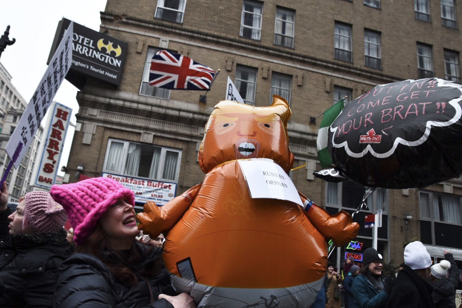 A protester holds a balloon featuring an orange baby with the likeness of Trump. The so-called “Trump baby blimp” was quickly embraced by left-wing American activists after a giant blimp took flight over London during Trump’s visit there last summer. (WTOP/Alejandro Alvarez)