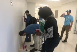 Volunteers paint a wall as part of the City Year MLK Day of Service at Ron Brown College Preparatory High School. (WTOP/Melissa Howell) 