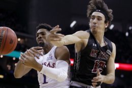 New Mexico State's Ivan Aurrecoechea, right, knocks the ball away from Kansas' Dedric Lawson (1) during the first half of an NCAA college basketball game Saturday, Dec. 8, 2018, in Kansas City, Mo. (AP Photo/Charlie Riedel)