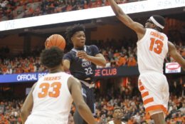 Old Dominion's Kalu Ezikpe, center, passes around Syracuse's Paschal Chukwu, right, and Syracuse's Ehijah Hughes, left, in the second half of an NCAA college basketball game in Syracuse, N.Y., Saturday, Dec. 15, 2018. Old Dominion won 68-62. (AP Photo/Nick Lisi)