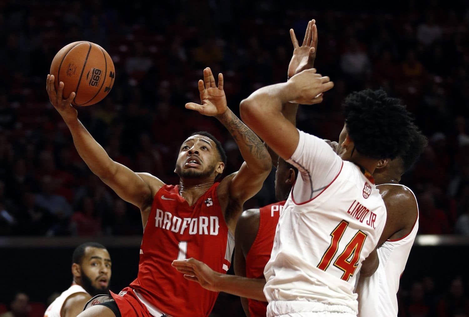 Radford guard Carlik Jones, left, shoots over Maryland forward Ricky Lindo Jr. (14) in the first half of an NCAA college basketball game, Saturday, Dec. 29, 2018, in College Park, Md. (AP Photo/Patrick Semansky)