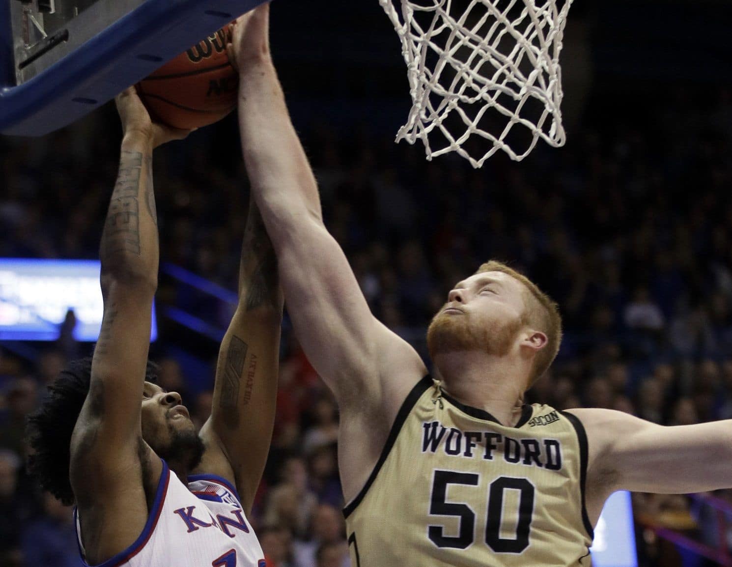 Kansas guard K.J. Lawson (13) is fouled by Wofford center Matthew Pegram (50) during the first half of an NCAA college basketball game in Lawrence, Kan., Tuesday, Dec. 4, 2018. (AP Photo/Orlin Wagner)