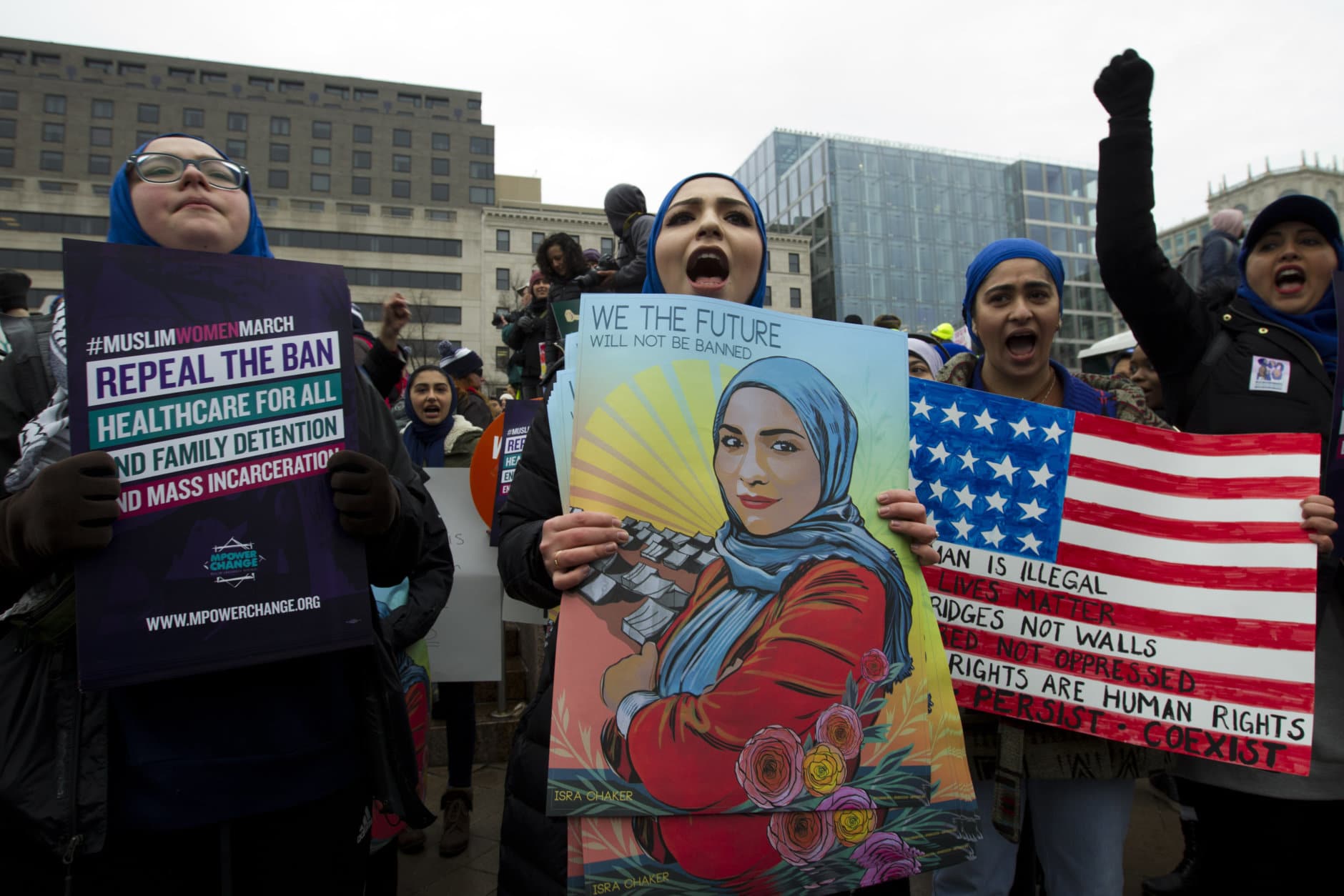 A group hold up signs at freedom plaza during the women's march in Washington on Saturday, Jan. 19, 2019. (AP Photo/Jose Luis Magana)