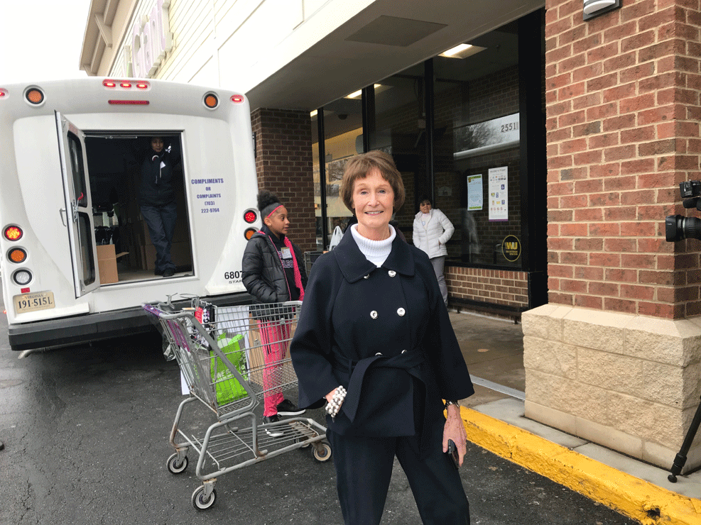 Fairfax County Board Of Supervisors Chairman Sharon Bulova helped to load donated food for those in need, including federal government workers onto a bus in Herndon. (WTOP/Dick Uliano)