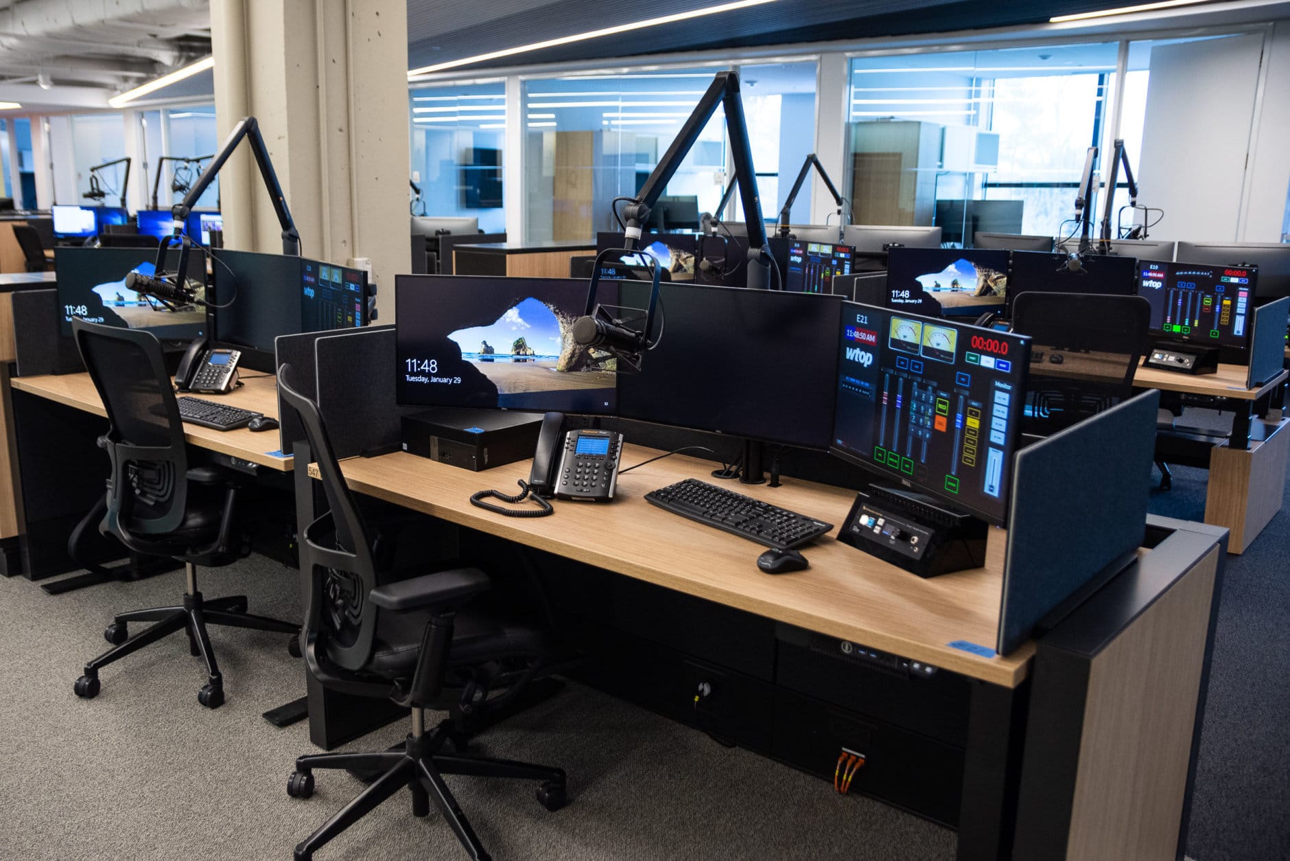 A typical reporter work station in WTOP's Wisconsin Avenue newsroom. Most stories from WTOP's radio reporters will be filed from stations like this one, featuring a virtual audio mixer, new system for phone interviews and the ability to go live on-air through the main control board located nearby in the new Glass-Enclosed Nerve Center. They can also convert into standing desks with the push of a button. (WTOP/Alejandro Alvarez)