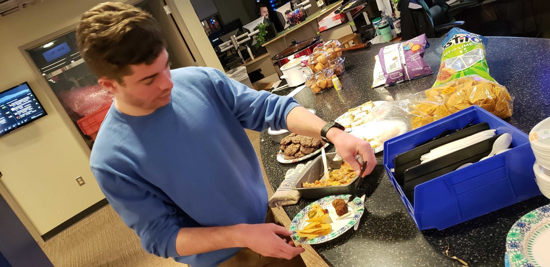 Assistant editor Teddy Gelman preparing his plate to get the proper energy to take on his shift. (WTOP/Brandon Millman) 