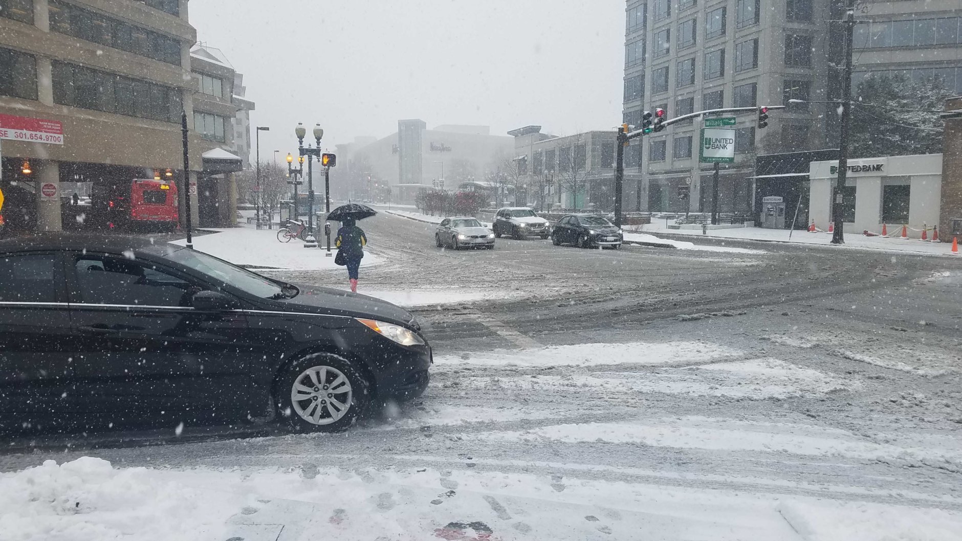 Snow blankets crosswalks and roadways in Chevy Chase. (WTOP/Will Vitka)