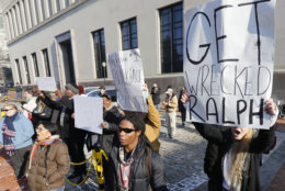 Demonstrators hold signs and chant outside the Governors office at the Capitol in Richmond, Va., Saturday, Feb. 2, 2019. The demonstrators are calling for the resignation of Virginia Governor Ralph Northam after a 30 year old photo of him on his medical school yearbook photo was widely distributed Friday. (AP Photo/Steve Helber)
