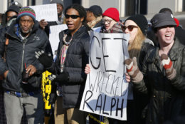 Demonstrators hold signs and chant outside the Governors office at the Capitol in Richmond, Va., Saturday, Feb. 2, 2019. The demonstrators are calling for the resignation of Virginia Governor Ralph Northam after a 30 year old photo of him on his medical school yearbook photo was widely distributed Friday. (AP Photo/Steve Helber)