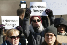 Demonstrators hold signs and chant outside the Governors Mansion at the Capitol in Richmond, Va., Saturday, Feb. 2, 2019. The demonstrators are calling for the resignation of Virginia Governor Ralph Northam after a 30 year old photo of him on his medical school yearbook photo was widely distributed Friday. (AP Photo/Steve Helber)