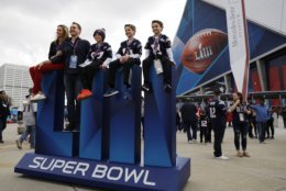 Fans pose outside the Mercedes-Benz Stadium before the NFL Super Bowl 53 football game between the Los Angeles Rams and the New England Patriots, Sunday, Feb. 3, 2019, in Atlanta. (AP Photo/David Goldman)