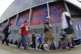 Fans walk near Mercedes-Benz Stadium before the NFL Super Bowl 53 football game between the Los Angeles Rams and the New England Patriots Sunday, Feb. 3, 2019, in Atlanta. (AP Photo/Charlie Riedel)