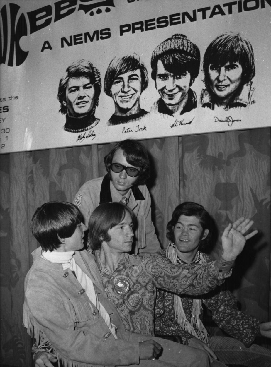 American pop band &quot;The Monkees&quot;, are seen beneath a poster with sketches of themselves, during their press conference in London, England, Thursday June 29, 1967. They are from left to right: Davy Jones, Peter Tork, Mike Nesmith and Micky Dolenz.. The band arrived yesterday and will give their first concert tomorrow at the Empire Pool, here in London. (AP Photo/Eddie Worth)