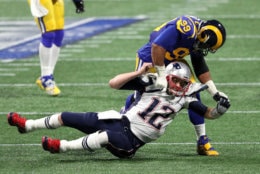 ATLANTA, GEORGIA - FEBRUARY 03:  Tom Brady #12 of the New England Patriots is tackled by Aaron Donald #99 of the Los Angeles Rams in the first quarter during Super Bowl LIII at Mercedes-Benz Stadium on February 03, 2019 in Atlanta, Georgia. (Photo by Patrick Smith/Getty Images)
