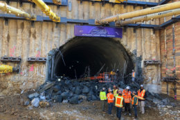 The Bethesda-to-New Carrollton Purple Line hit a milestone Thursday as crews broke down the last barrier between a short section of tunnel and the site of a future station in Silver Spring. (WTOP/John Aaron)