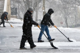 Maintenance crews shovel snow in Tenleytown. (WTOP/Dave Dildine)