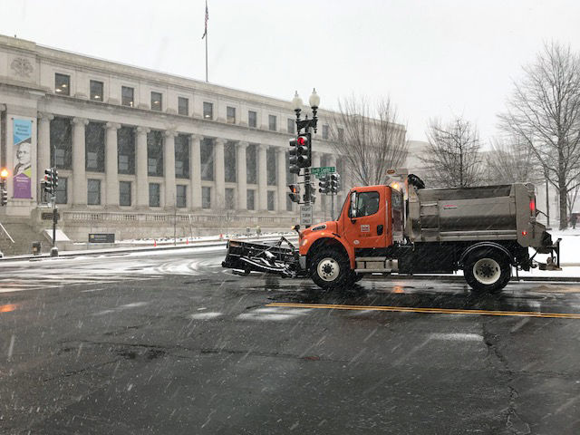 A snow plow makes its way through the District near Union Station. (WTOP/Steve Dresner)