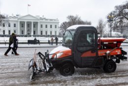 A small plow clears Pennsylvania Avenue outside the White House’s north lawn on Wednesday. With the federal government closed, most of downtown D.C. was empty save for a few tourists snapping selfies in the snow. (WTOP/Alejandro Alvarez)