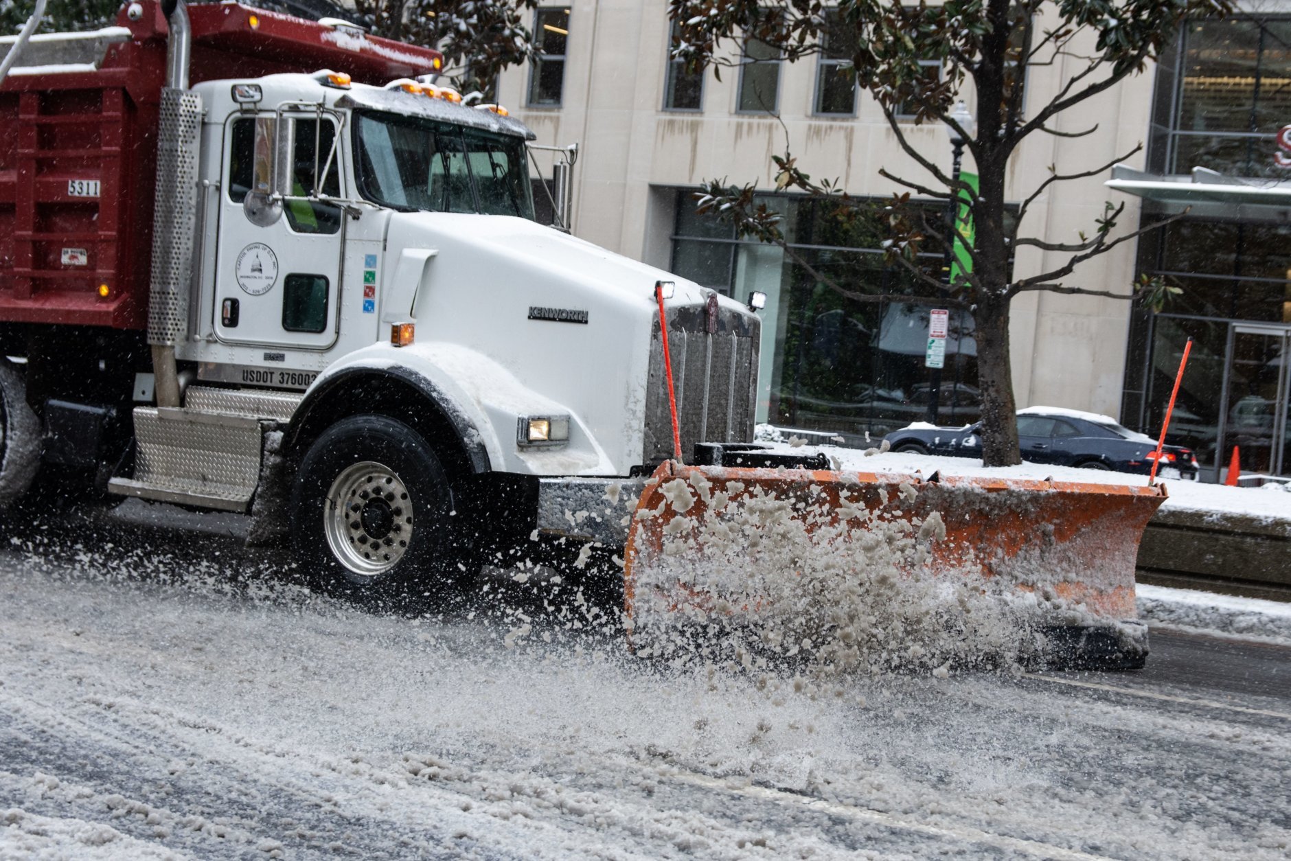 A snow plow clears slush off Connecticut Avenue on Wednesday afternoon. (WTOP/Alejandro Alvarez)